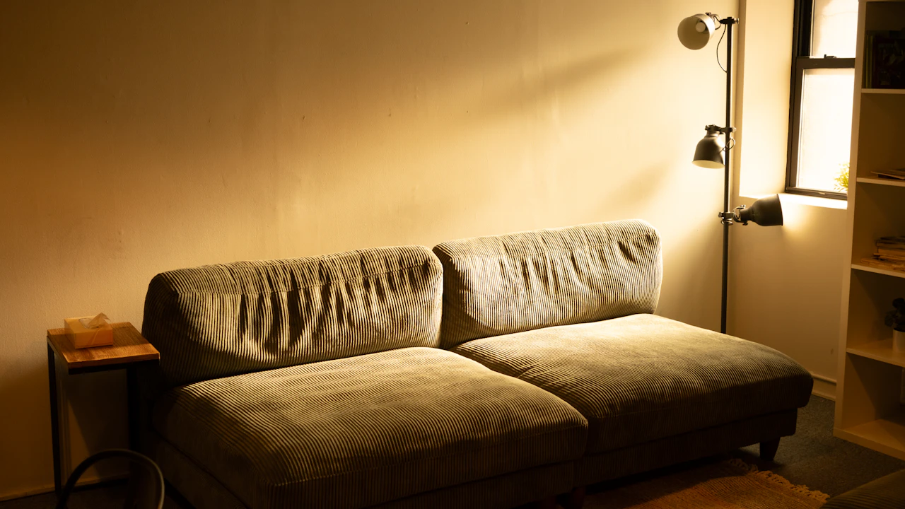 Sofa und Stehlampe in einem warm beleuchteten Wohnbereich